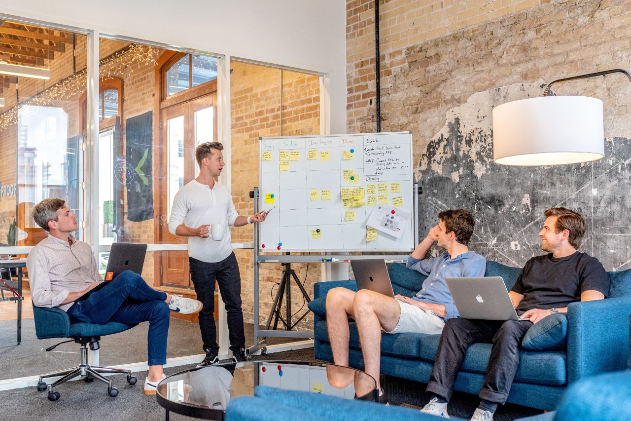 IT consultant explaining something to a group using a whiteboard