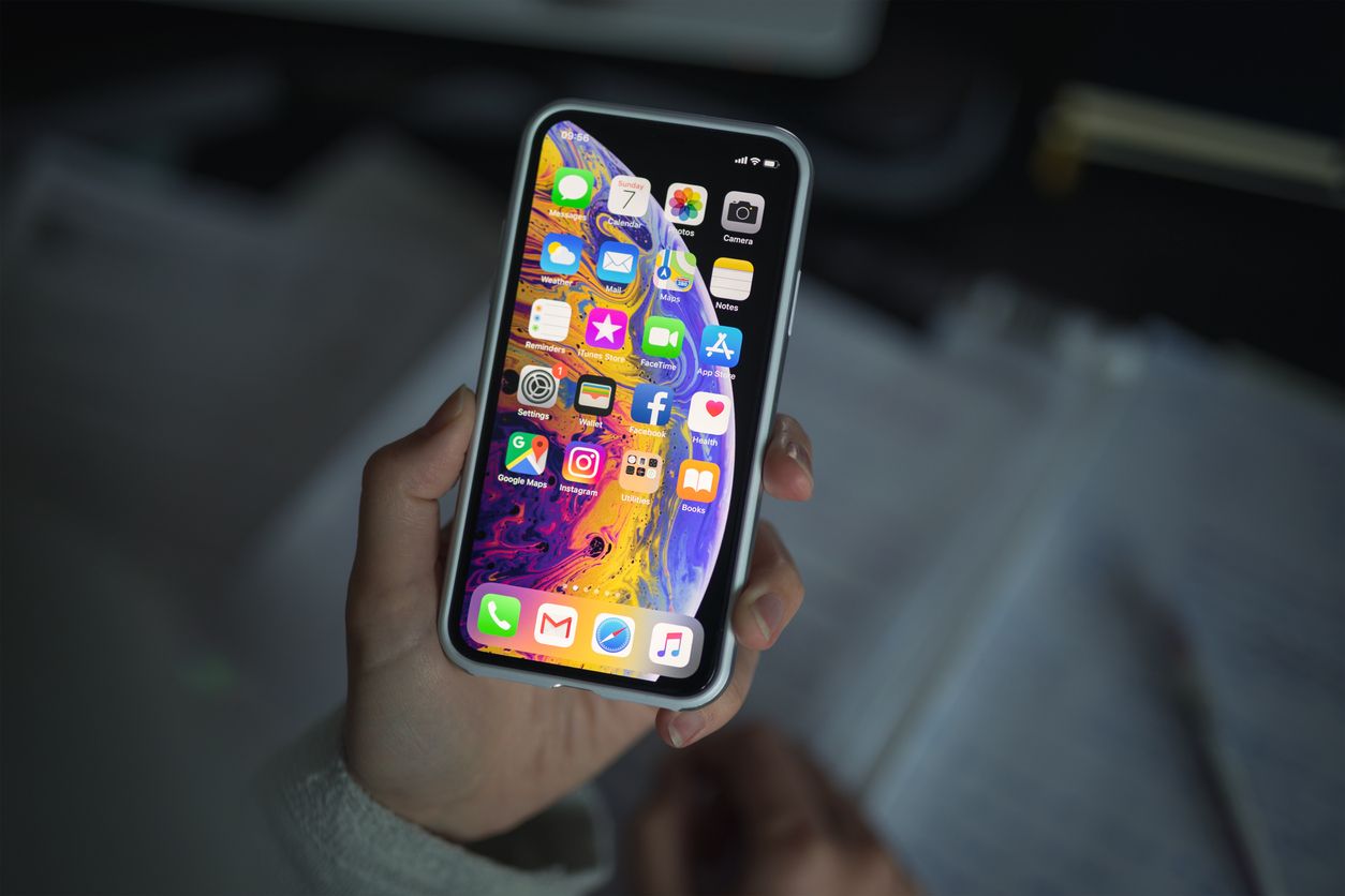 iOS App Development concept; Woman holding new iPhone XS smartphone